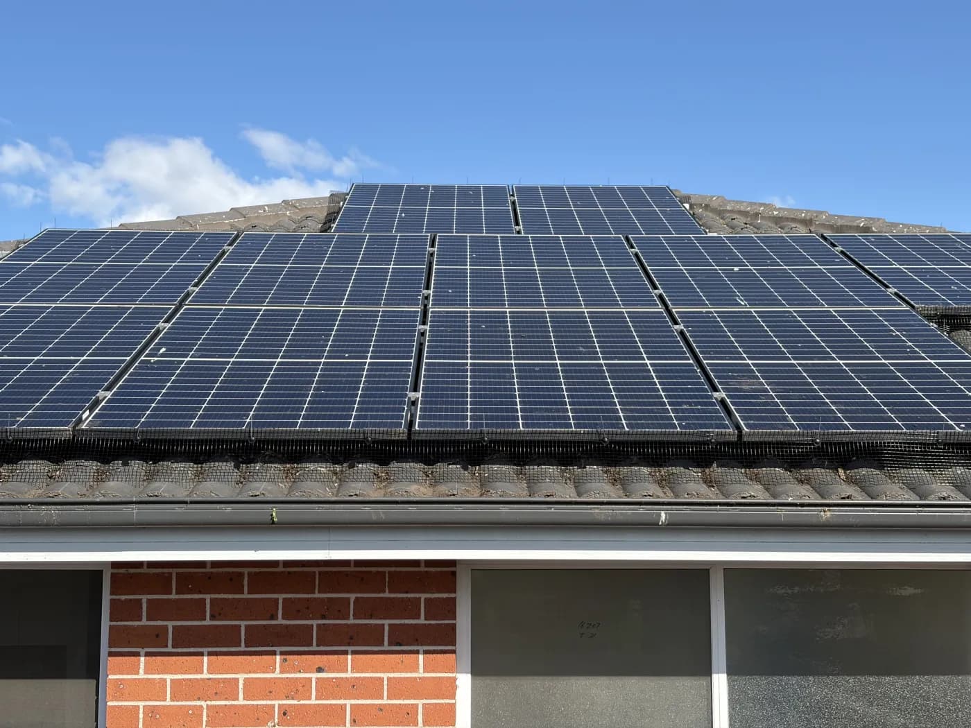 The same style of roofline after bird proofing, with stainless mesh sealing the solar array and no birds in sight