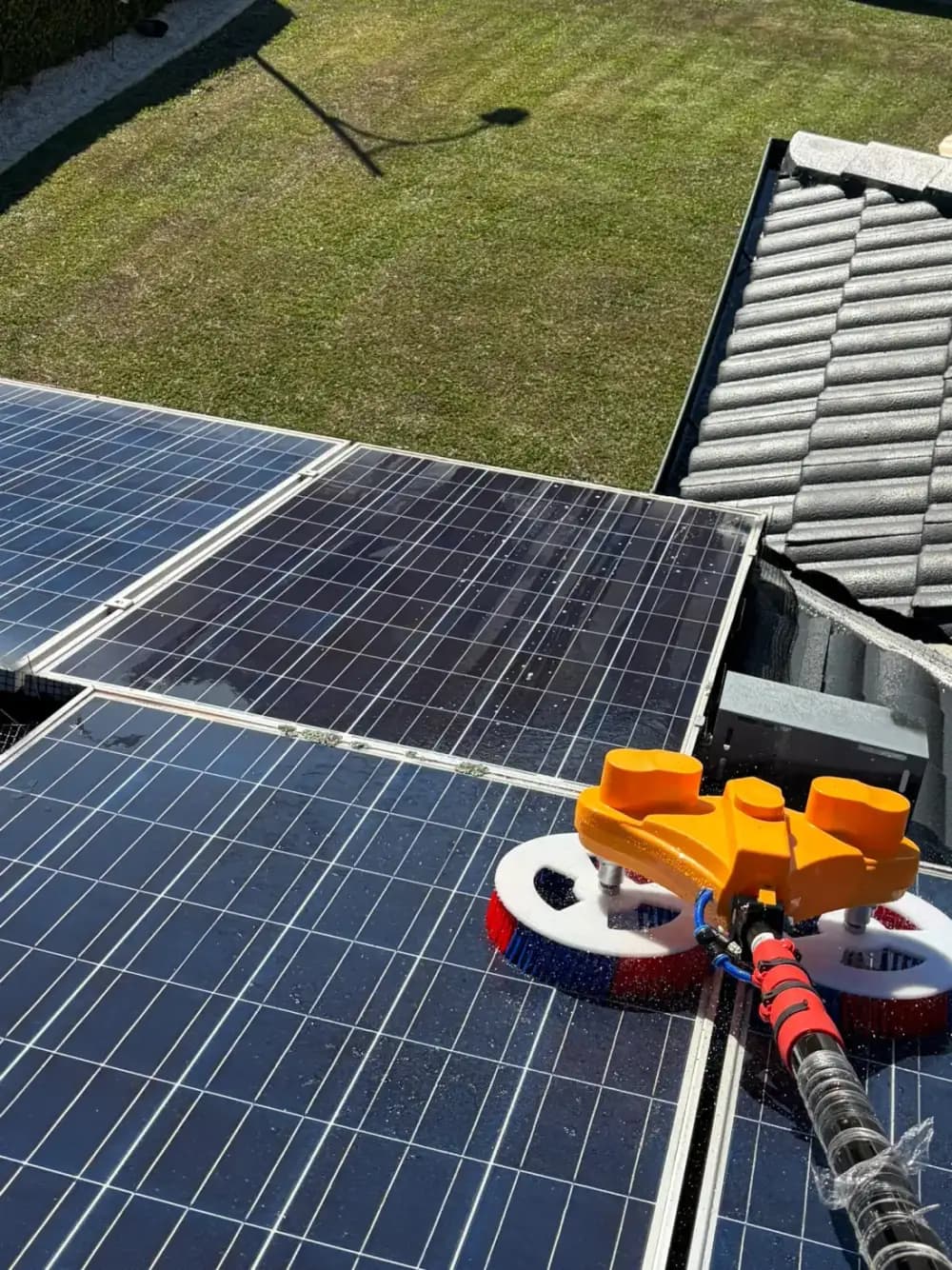 Soft rotary brush washing rooftop solar panels with purified water