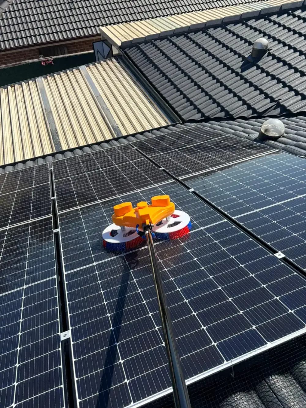 Rotary brush cleaning solar panels with purified water