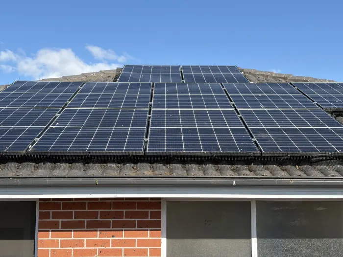 Solar panels protected by bird mesh along the finished roofline