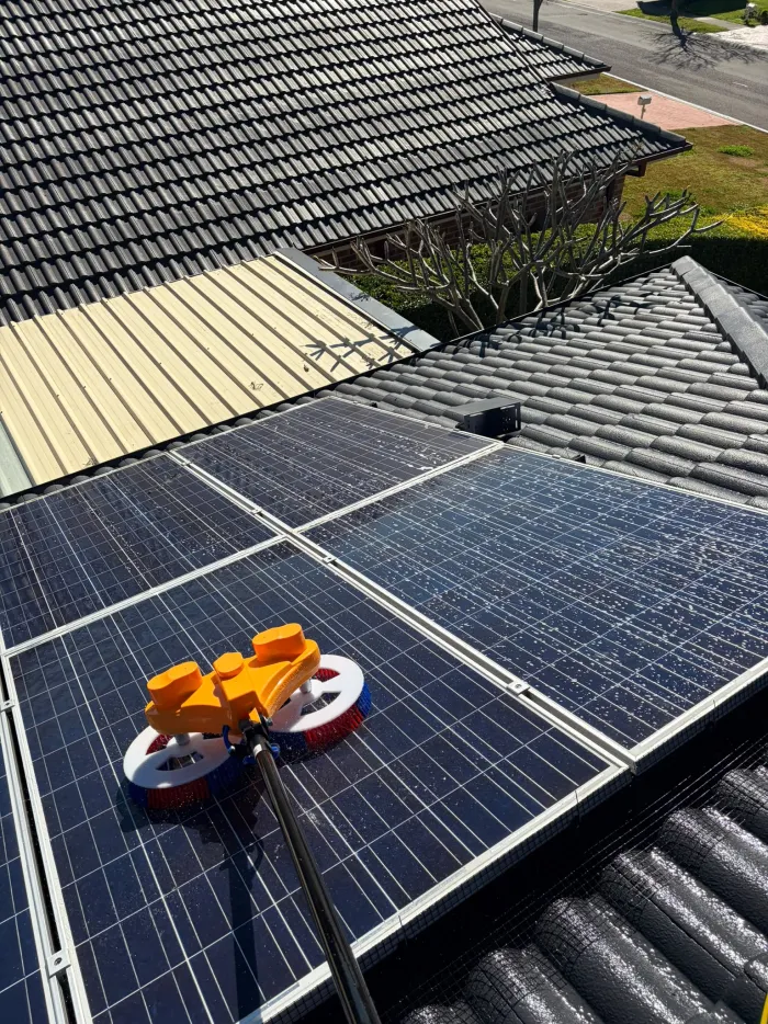Purified water brush moving across polycrystalline solar panels during a clean